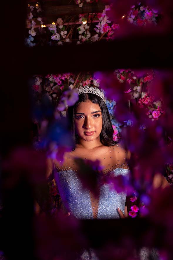 Retrato da debutante com coroa emoldurado por flores