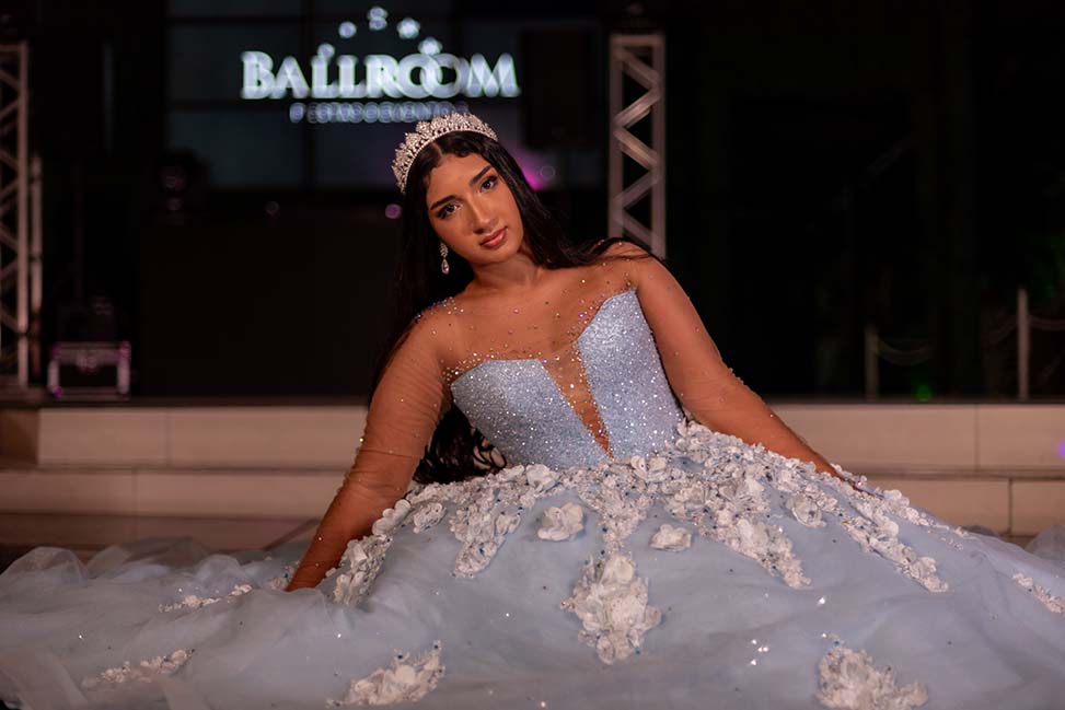 Debutante sentada com o vestido azul espalhado ao redor