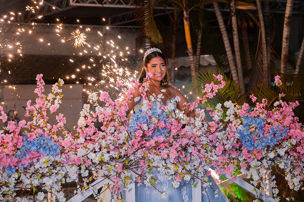 Debutante em vestido azul diante da chuva de prata na área externa