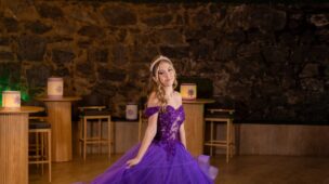 Debutante em vestido roxo de baile diante do letreiro luminoso na festa de 15 anos tema Rapunzel