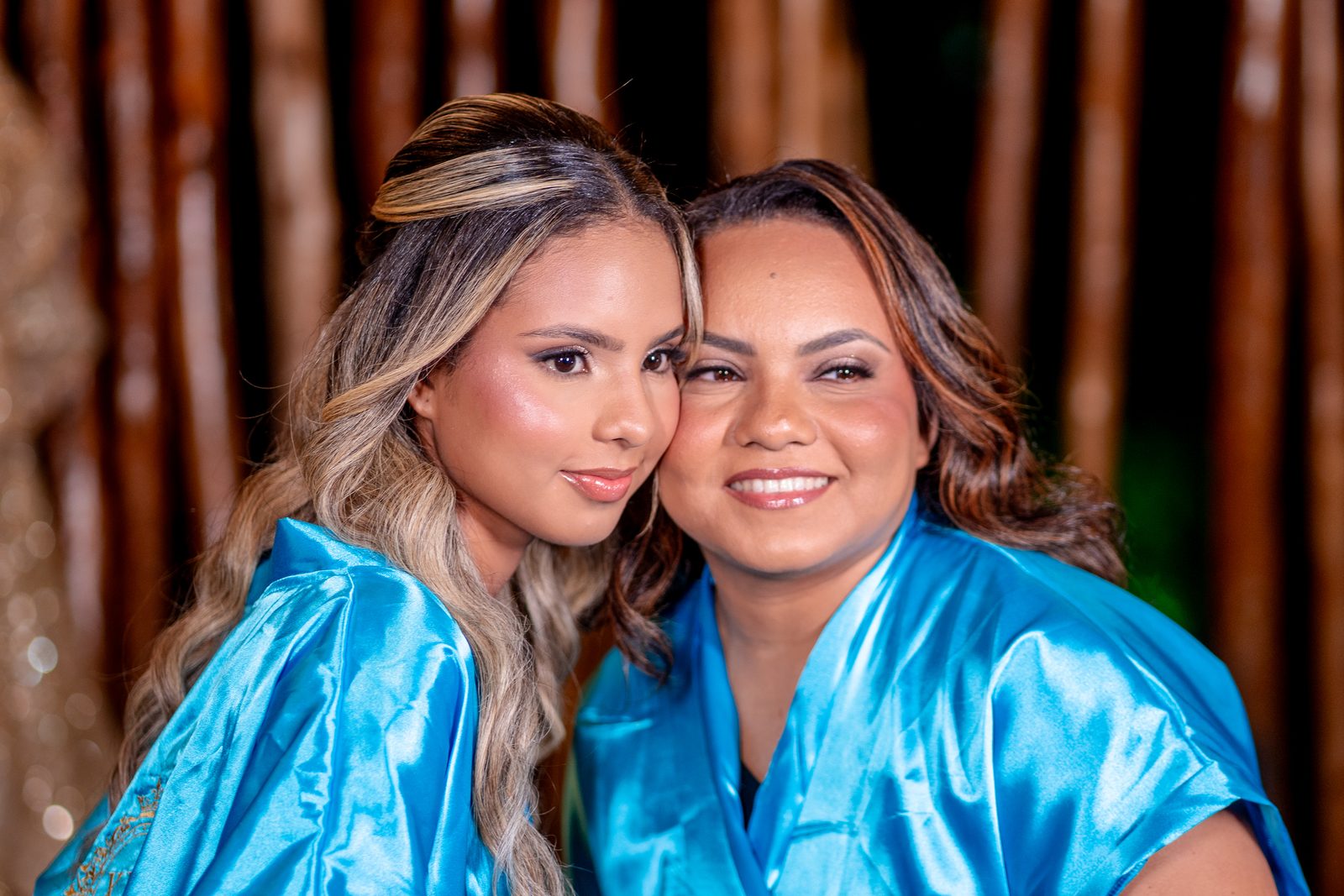 Debutante e sua mae emocionadas de robe azul no making of dos 15 anos