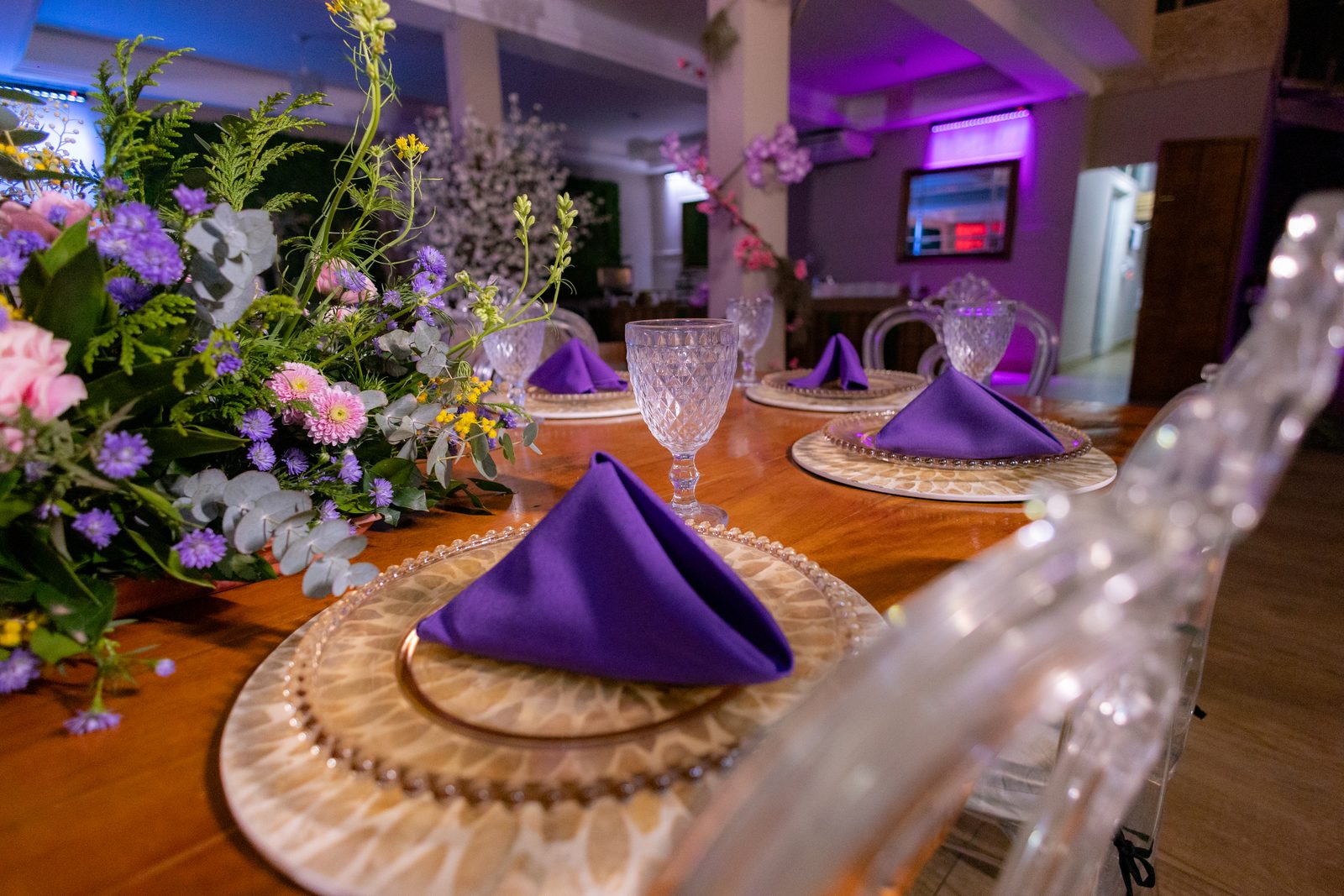 Mesa posta com arranjos de flores silvestres e cristais na festa de 15 anos