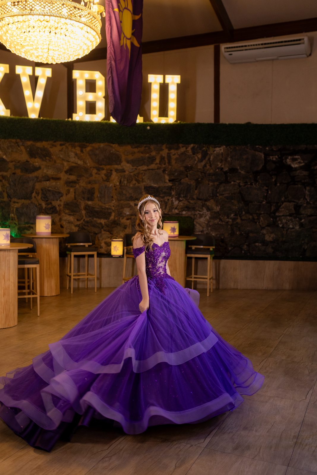 Retrato da debutante em vestido roxo de baile no salao da festa de 15 anos