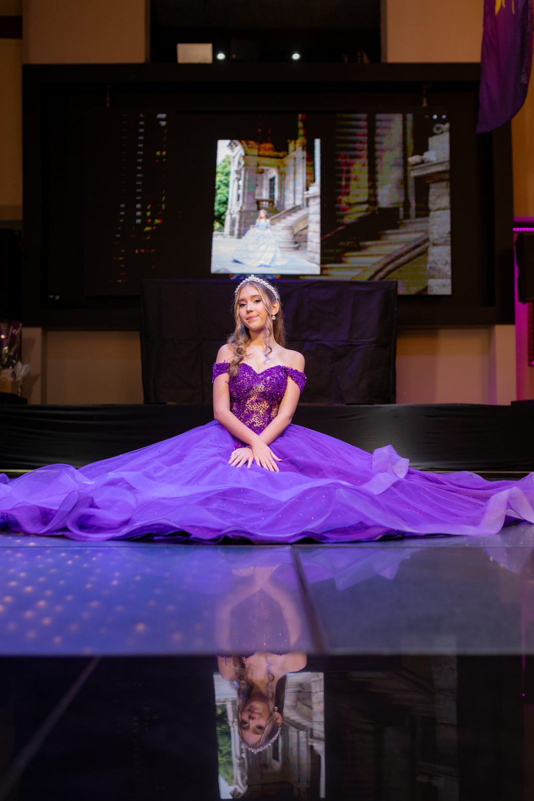 Debutante diante do telao com a torre da Rapunzel projetada ao fundo