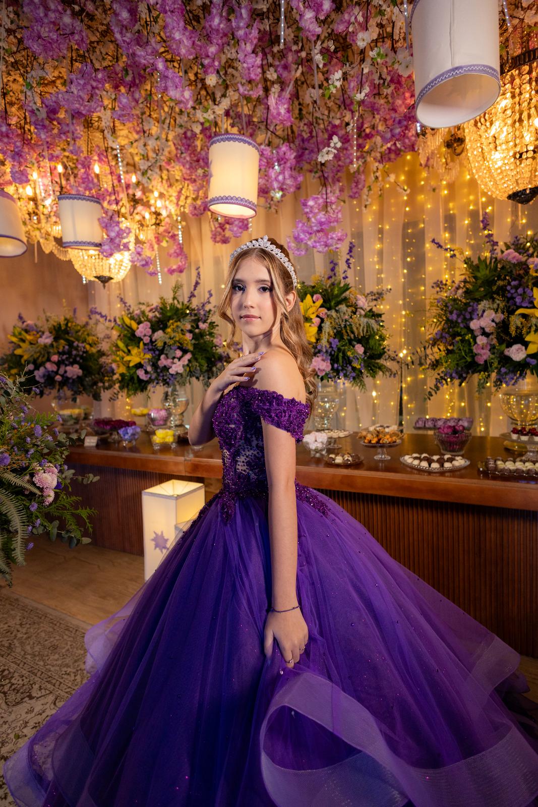 Mesa de doces decorada com arranjos florais na festa de 15 anos tema Rapunzel