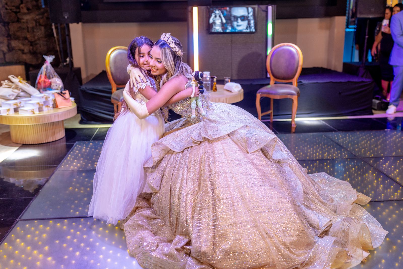 Debutante abraca a irma cacula durante a festa de 15 anos