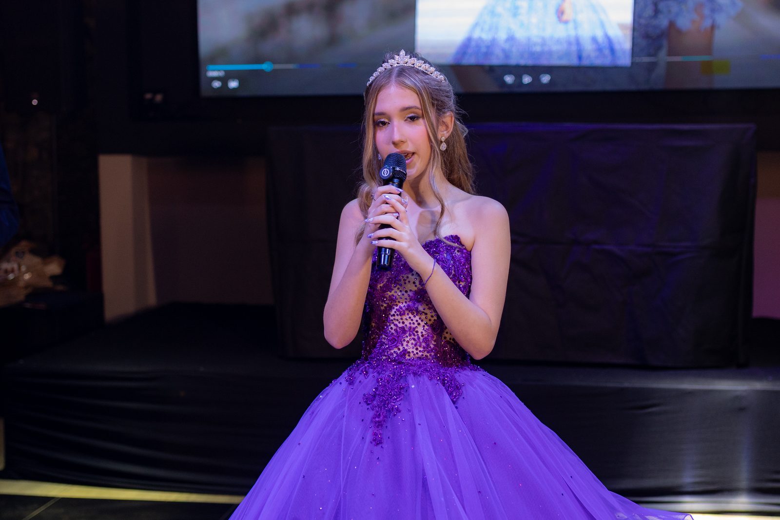 Debutante faz seu discurso ao microfone diante dos convidados