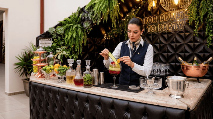 Bartender prepara drinques no bar da festa